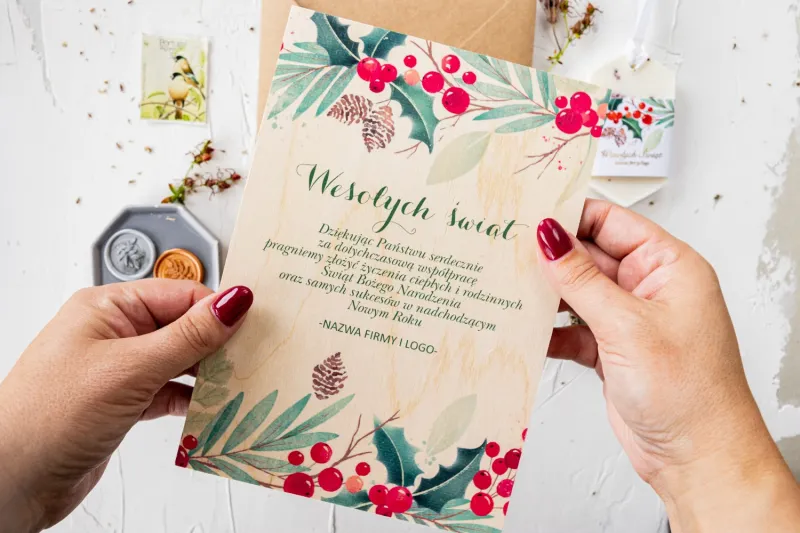 Drewniana kartka świąteczna z motywem gałązek i czerwonej jarzębiny, dostosowywana dla firm z ich logo i specjalnymi życzeniami. Drewniana kartka świąteczna z motywem gałązek i czerwonej jarzębiny, dostosowywana dla firm z ich logo i specjalnymi życzeniami.