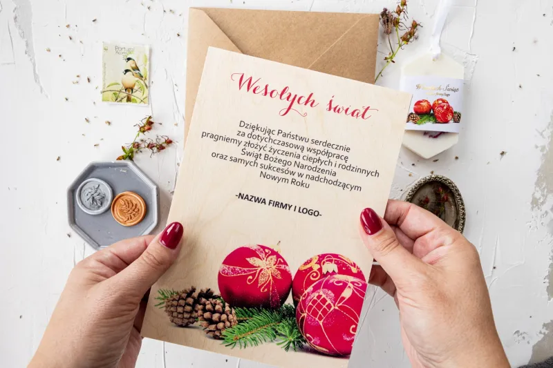 Drewniana kartka świąteczna z czerwonymi bombkami i zieloną gałązką, dostosowywana dla firm z ich logo Drewniana kartka świąteczna z czerwonymi bombkami i zieloną gałązką, dostosowywana dla firm z ich logo