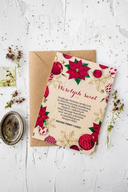 Czerwona drewniana kartka świąteczna z grafiką bombek i kwiatów, dostosowywana dla firm z ich logo i treścią życzeń.