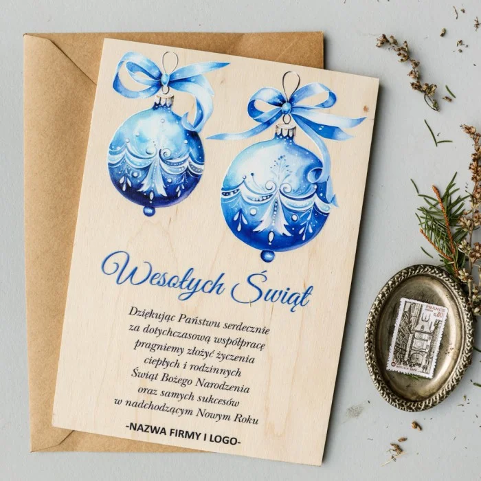 Drewniana kartka świąteczna z grafiką niebieskich bombek i możliwością personalizacji logo firmy.