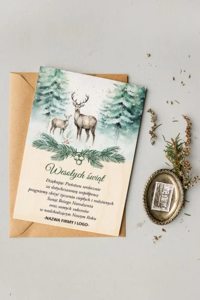 Drewniana kartka świąteczna z grafiką pary jeleni w zimowym lesie z logo firmy