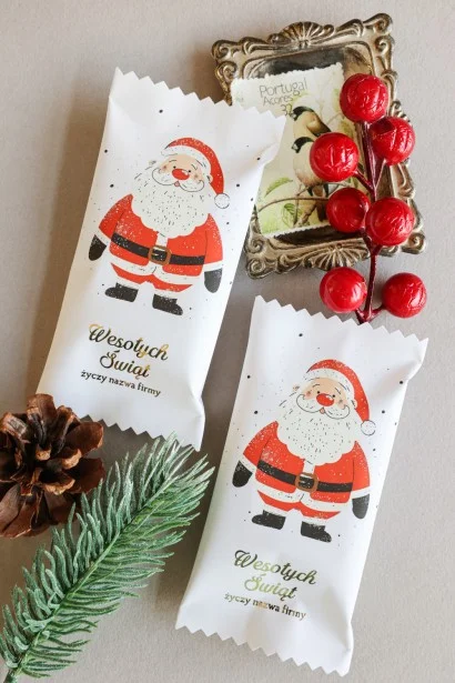 Personalizowane czekoladki świąteczne z logo firmy w eleganckim białym opakowaniu z wizerunkiem Mikołaja.