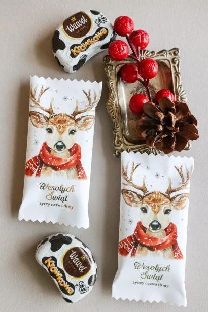 Personalizowane czekoladki świąteczne z logo firmy w eleganckim białym opakowaniu z grafiką renifera w czerwonym szaliku.