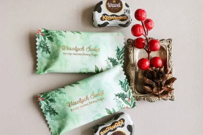Personalizowane czekoladki świąteczne z logo firmy w eleganckim zielonym opakowaniu z grafiką ostrokrzewu.