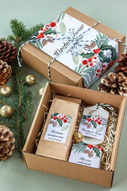 Elegancki firmowy box świąteczny z zieloną grafiką, zawierający herbatę, czekoladkę i zawieszkę zapachową