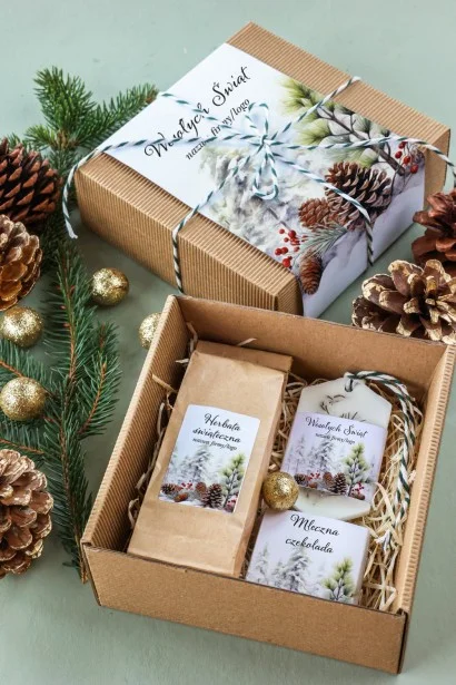 Elegancki zimowy box z herbatą, czekoladą i zawieszką zapachową, z motywem zaśnieżonych drzew i szyszek