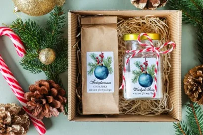 Elegancki świąteczny box z herbatą i świeczką sojową, z motywem niebieskiej bombki i zielonych gałązek świerku