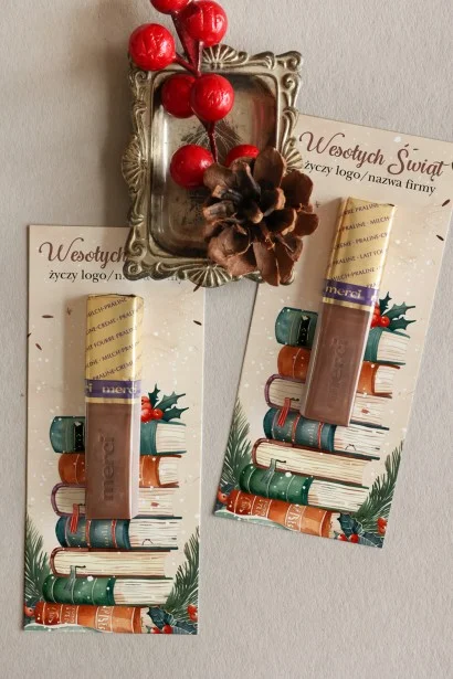 Czekoladki Merci w świątecznym kartoniku z ilustracją książek i gałązek ostrokrzewu, personalizowane logo firmy.
