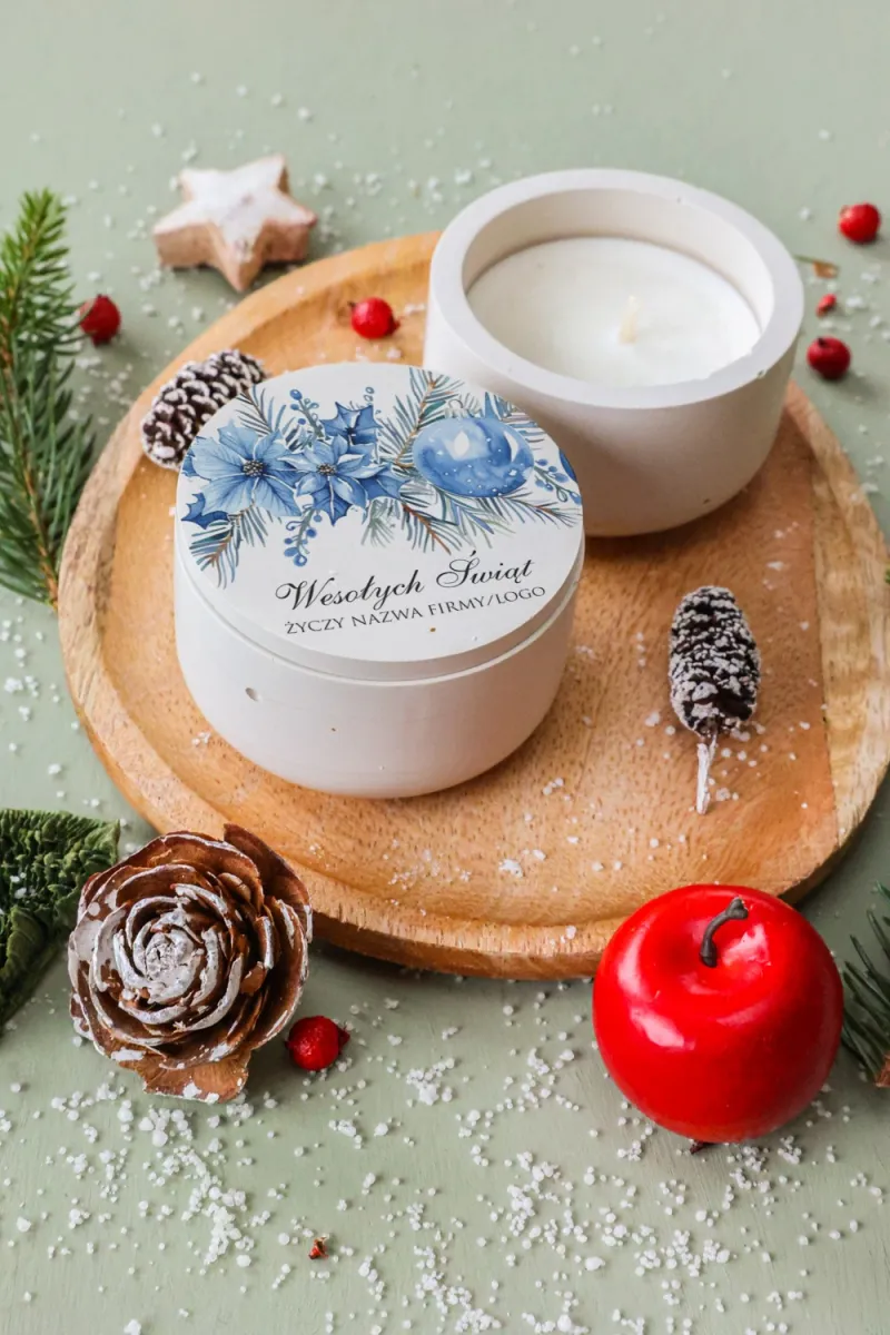 Świeca sojowa z elegancką kompozycją niebieskich poinsecji i bombki, idealna na upominek firmowy. Świeca sojowa z elegancką kompozycją niebieskich poinsecji i bombki, idealna na upominek firmowy.