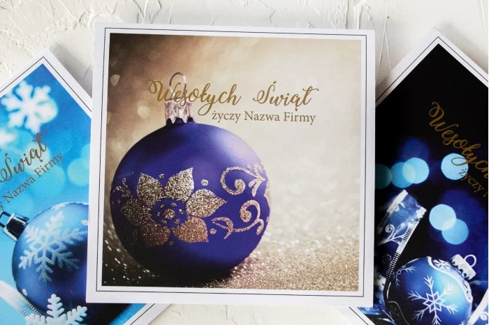 Elegancka kartka świąteczna z grafiką niebieskiej bombki ze złoceniem, idealna dla firm z opcją personalizacji logo i życzeń.